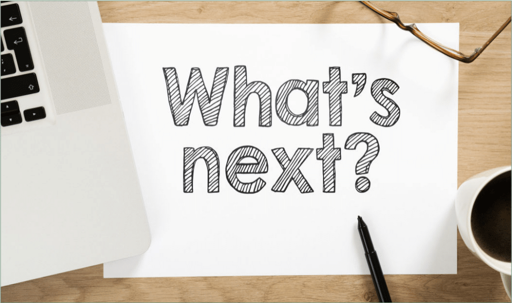 A Piece Of Paper Sitting Under A Laptop With A Pen Sitting At The Bottom. The Paper Says &Quot;Whats Next&Quot;.