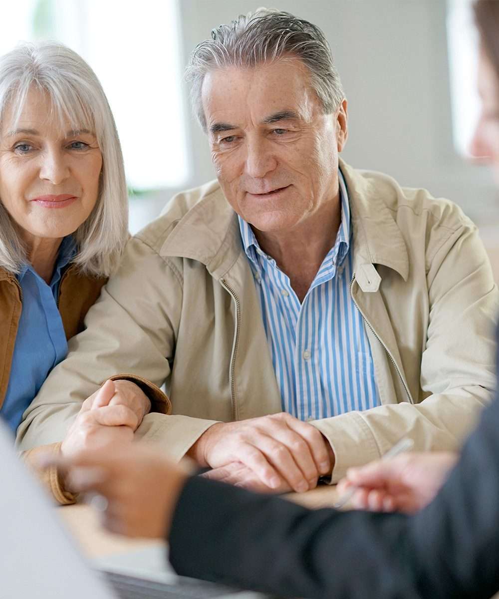 an elderly couple talking about retirement planning with a financial advisor