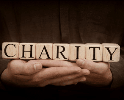 An Image Of A Person Holding Letter Blocks That Spell Out Charity