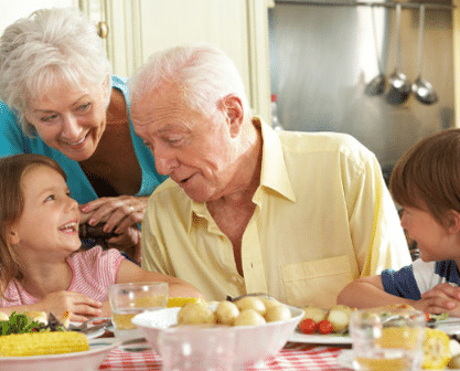 An Image Of Two Elderly People Hanging Out With Their Grandkids.