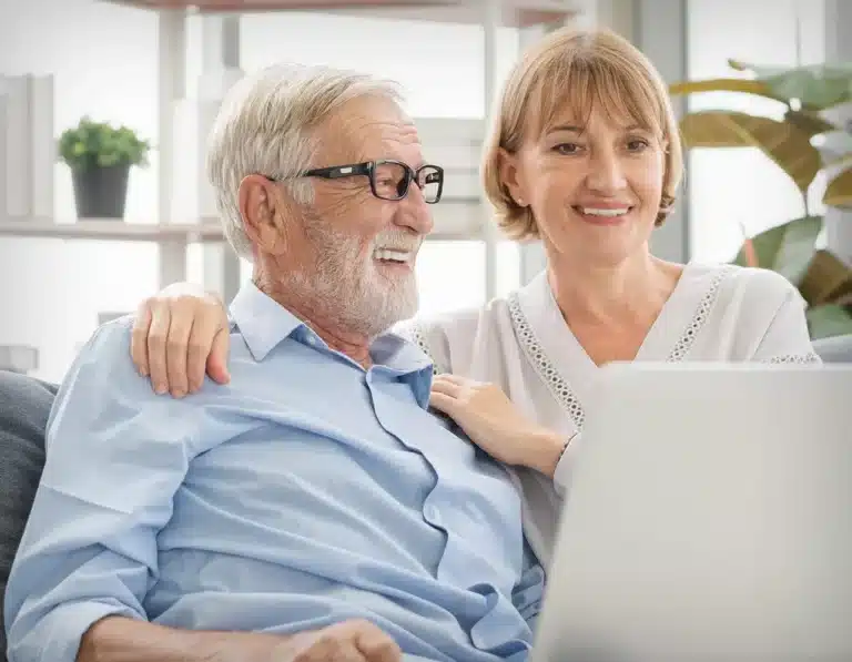 A Retired Couple Looking At A Laptop Screen.